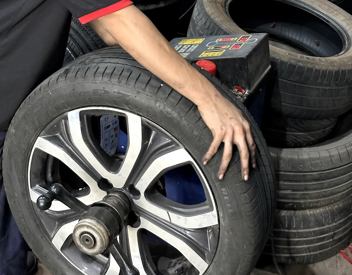 Roda presa no eixo da máquina balanceadora